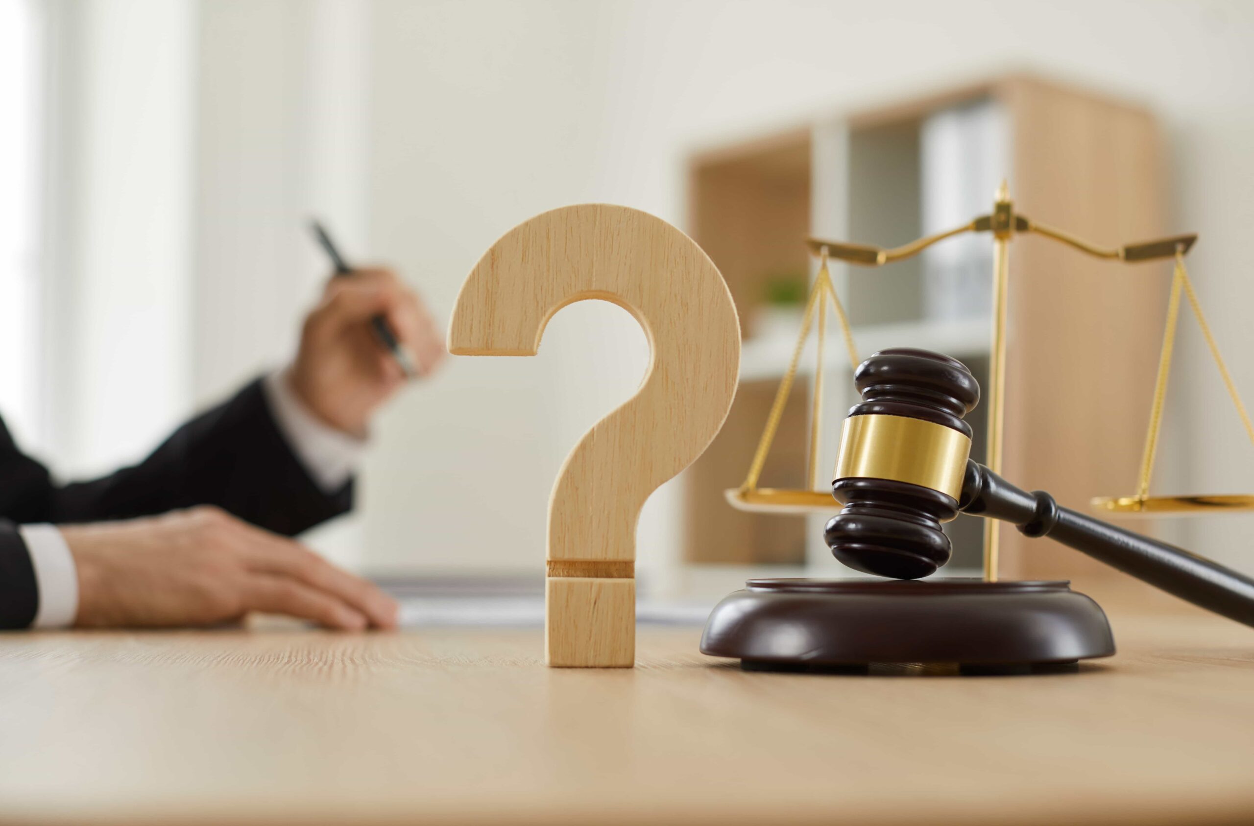 Legal concept with gavel, justice scales, and question mark symbolizing legal advice or uncertainty in law.