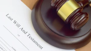 a legal document titled last will and testament near a gavel and pen